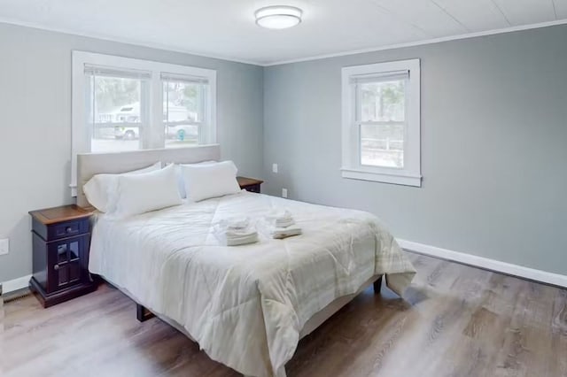 bedroom featuring wood-type flooring and ornamental molding