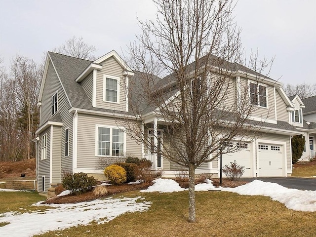 view of front facade featuring a garage, roof with shingles, and aphalt driveway