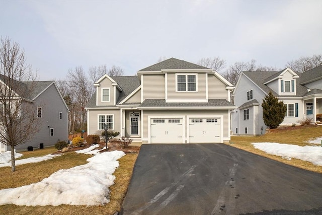 view of front of home featuring a garage, driveway, and a shingled roof