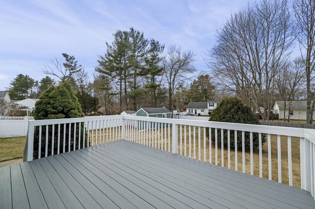 wooden terrace featuring an outdoor structure and fence