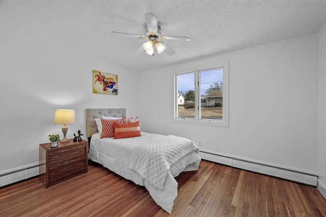 bedroom featuring a baseboard radiator, a textured ceiling, and hardwood / wood-style floors