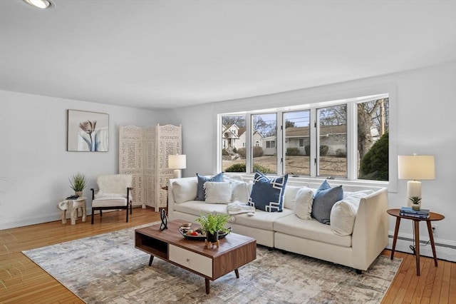 living area with hardwood / wood-style floors, baseboards, and a baseboard radiator