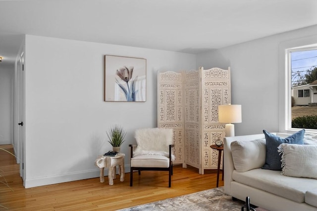 sitting room with baseboards and wood finished floors