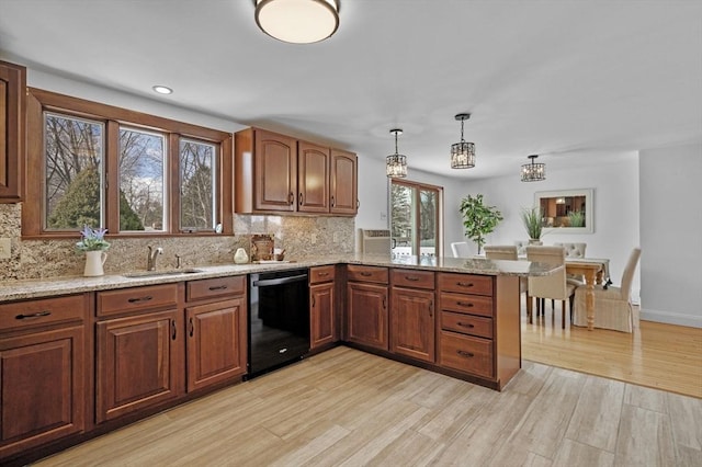 kitchen featuring light wood-type flooring, a sink, tasteful backsplash, light stone countertops, and dishwasher