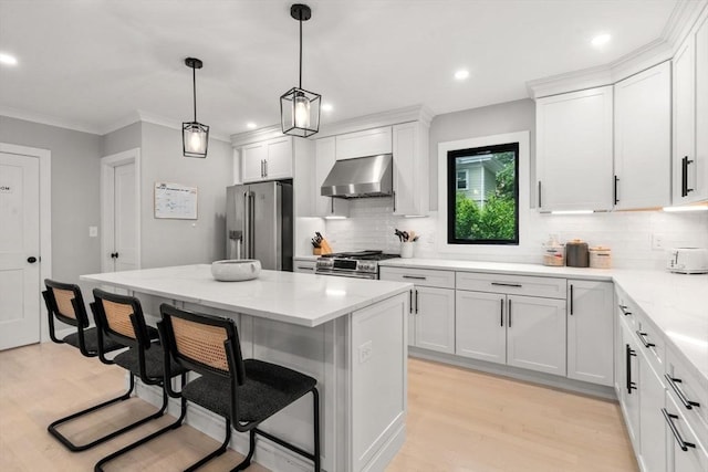 103 Warwick Rd Unit 103, Newton, MA 02465 - kitchen with wall chimney range hood, premium appliances, a kitchen breakfast bar, decorative backsplash, and light wood-style flooring