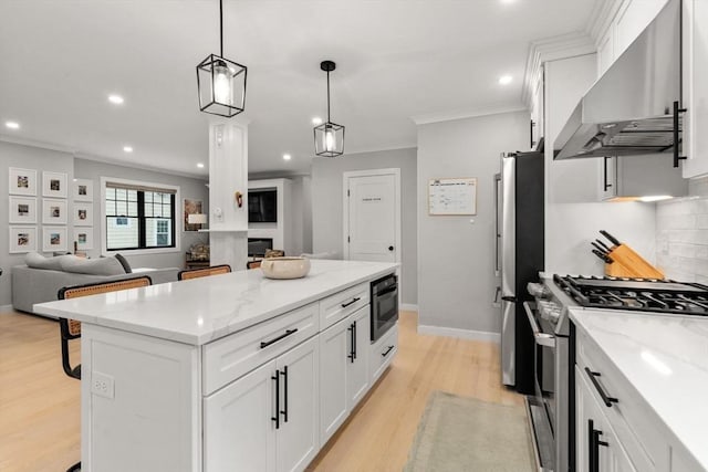 103 Warwick Rd Unit 103, Newton, MA 02465 - kitchen featuring wall chimney exhaust hood, appliances with stainless steel finishes, ornamental molding, white cabinets, and a kitchen island