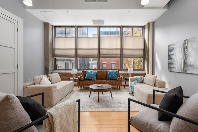 interior space featuring a baseboard heating unit, light wood-type flooring, and a wall of windows