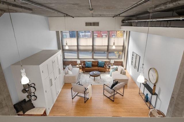 unfurnished living room with a high ceiling and light hardwood / wood-style floors