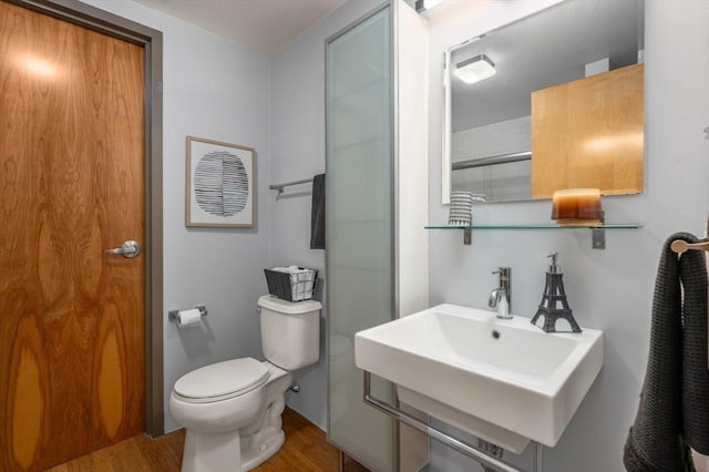 bathroom with toilet, hardwood / wood-style flooring, and sink