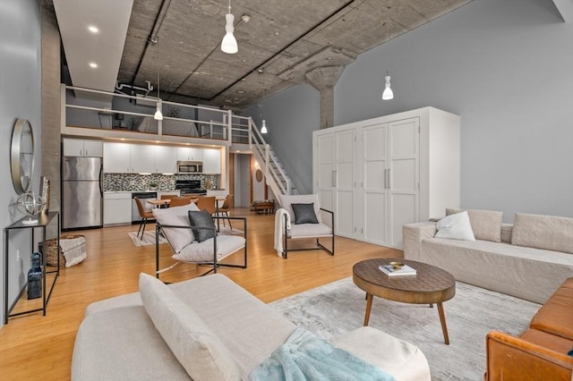 living room featuring a high ceiling and light hardwood / wood-style flooring