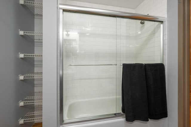 bathroom with bath / shower combo with glass door