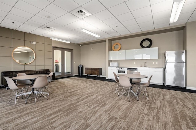 dining space featuring sink and light carpet