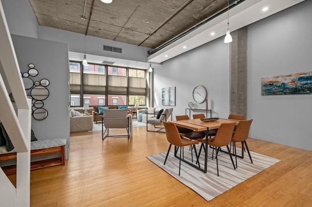 dining room featuring a high ceiling and light wood-type flooring