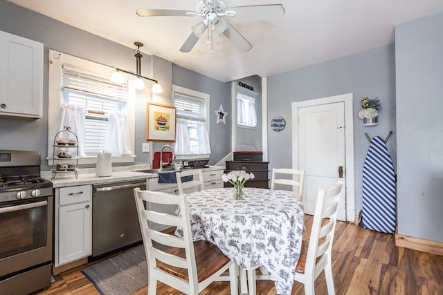 dining space featuring a healthy amount of sunlight, ceiling fan, dark wood-type flooring, and sink