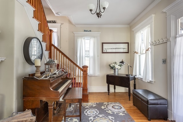 foyer entrance with an inviting chandelier, light hardwood / wood-style flooring, and ornamental molding