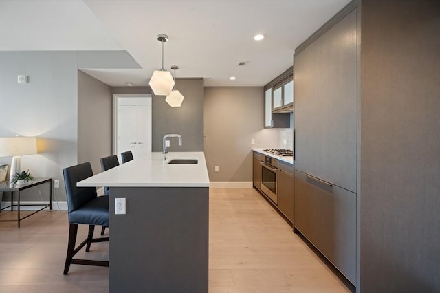 100 Lovejoy Wharf Unit 6J, Boston, MA 02114 - kitchen with a sink, a breakfast bar, appliances with stainless steel finishes, light wood-style flooring, and recessed lighting
