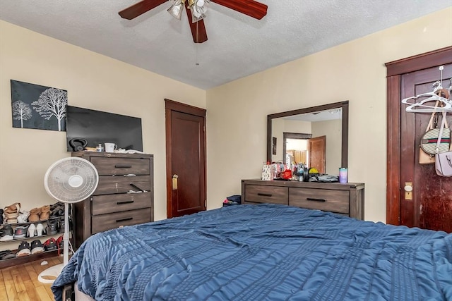 bedroom featuring wood-type flooring, a textured ceiling, and ceiling fan