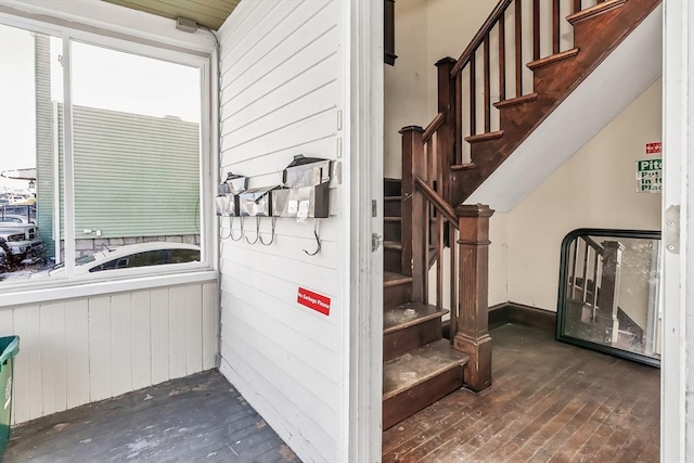 stairs featuring hardwood / wood-style floors and wood walls