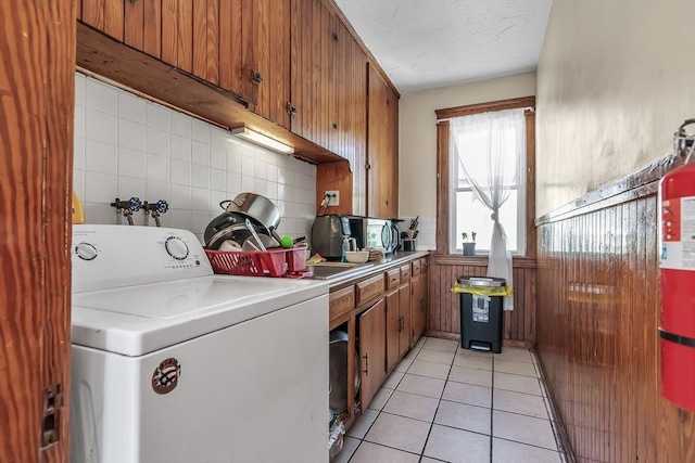 kitchen featuring tasteful backsplash, washer / clothes dryer, and light tile patterned floors