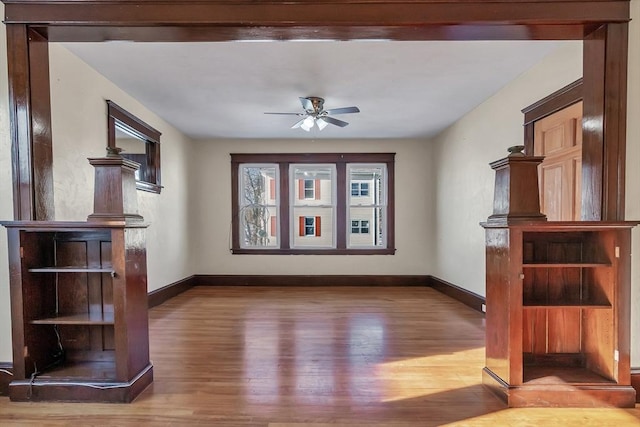 unfurnished living room with wood-type flooring and ceiling fan