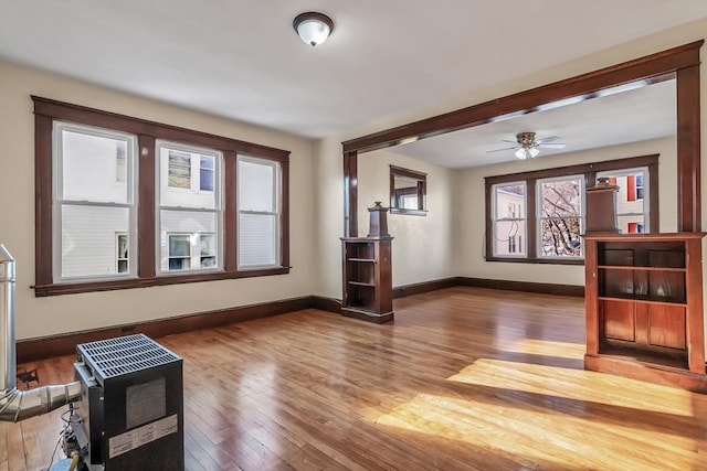 living room featuring hardwood / wood-style flooring, heating unit, and ceiling fan