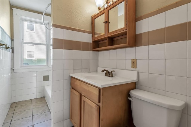 bathroom with tile patterned flooring, vanity, tile walls, and toilet