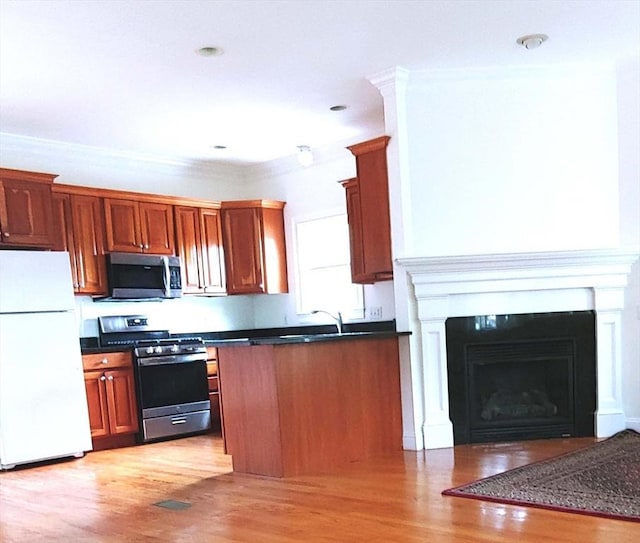 97-99 N St Unit 97, Newton, MA 02460 - kitchen featuring stainless steel appliances, dark countertops, light wood-type flooring, brown cabinets, and crown molding