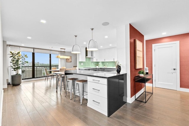50 Longwood Ave Unit 1016/1017, Brookline, MA 02446 - kitchen with dark wood finished floors, white cabinetry, a breakfast bar area, recessed lighting, and expansive windows
