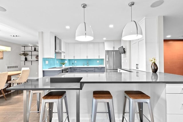 50 Longwood Ave Unit 1016/1017, Brookline, MA 02446 - kitchen featuring freestanding refrigerator, wall chimney range hood, a peninsula, tasteful backsplash, and white cabinets