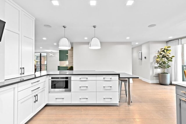 50 Longwood Ave Unit 1016/1017, Brookline, MA 02446 - kitchen featuring oven, white cabinets, recessed lighting, light wood-type flooring, and dark countertops