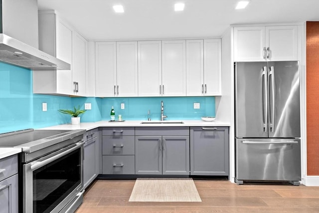 50 Longwood Ave Unit 1016/1017, Brookline, MA 02446 - kitchen featuring stainless steel appliances, wall chimney exhaust hood, gray cabinetry, a sink, and light countertops