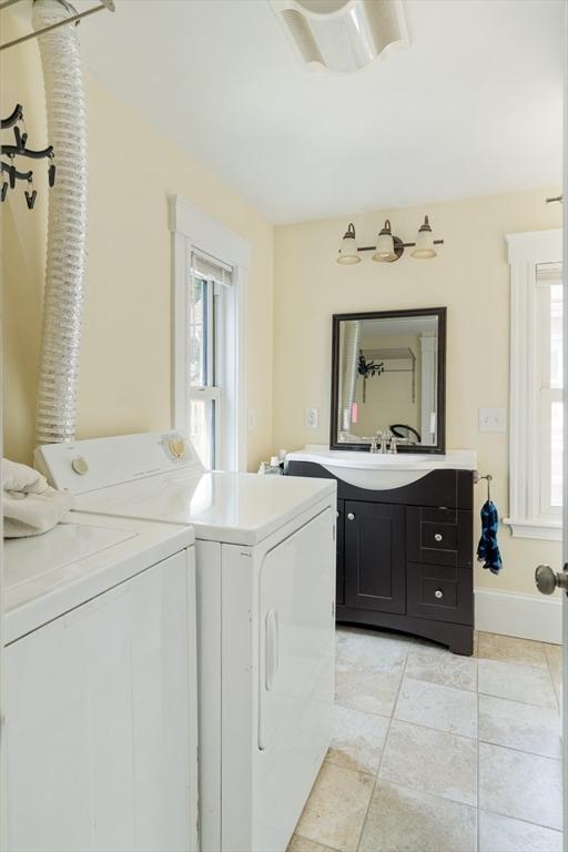 15 Berkeley St, Somerville, MA 02143 - washroom featuring separate washer and dryer, light tile patterned flooring, and cabinet space