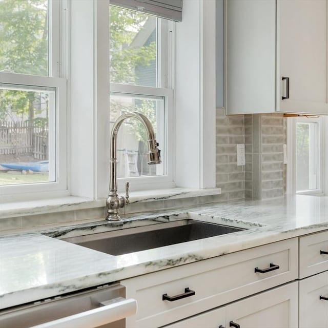 15 Berkeley St, Somerville, MA 02143 - kitchen featuring decorative backsplash, dishwasher, light stone counters, and white cabinets