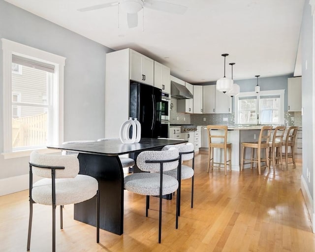 15 Berkeley St, Somerville, MA 02143 - kitchen featuring wall chimney exhaust hood, fridge, tasteful backsplash, and ceiling fan