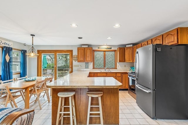 22 Woodside Dr, Falmouth, MA 02536 - kitchen with appliances with stainless steel finishes, a peninsula, light tile patterned floors, light countertops, and recessed lighting