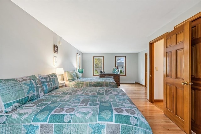 22 Woodside Dr, Falmouth, MA 02536 - bedroom with a baseboard heating unit, light wood-style floors, and baseboards