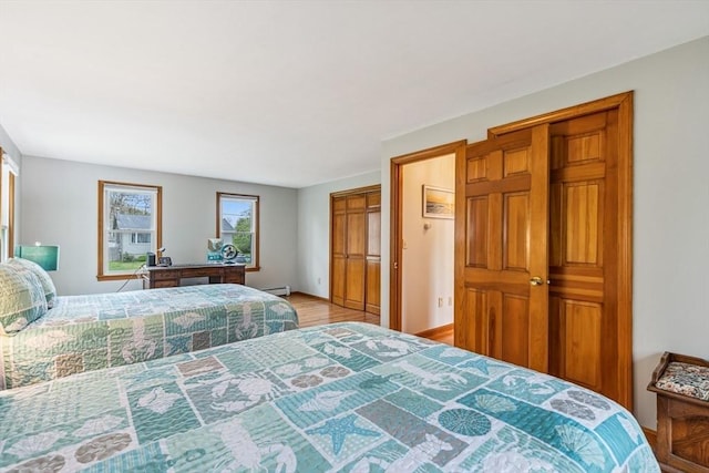 22 Woodside Dr, Falmouth, MA 02536 - bedroom featuring baseboard heating, wood finished floors, and baseboards