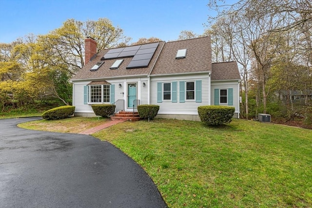 22 Woodside Dr, Falmouth, MA 02536 - cape cod home featuring solar panels, a chimney, a front lawn, cooling unit, and roof with shingles