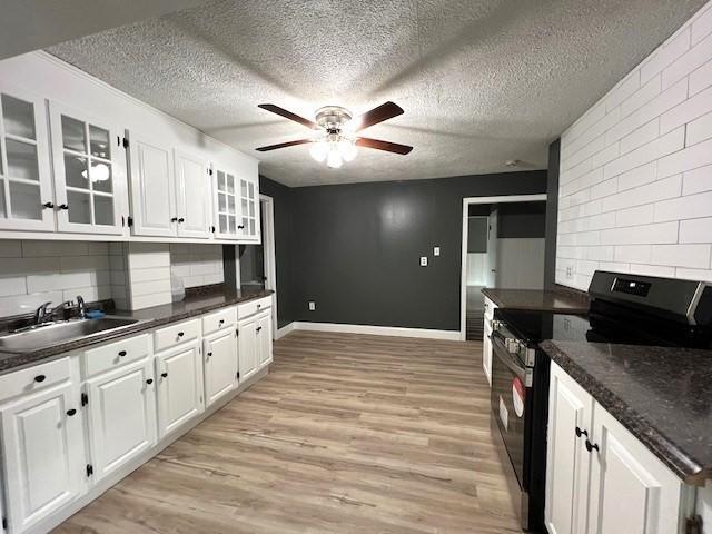 14 Felton St, Fitchburg, MA 01420 - kitchen featuring black / electric stove, ceiling fan, dark countertops, white cabinets, and light wood-style floors