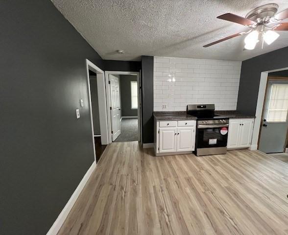 14 Felton St, Fitchburg, MA 01420 - kitchen with electric range, dark countertops, a textured ceiling, light wood-style flooring, and ceiling fan