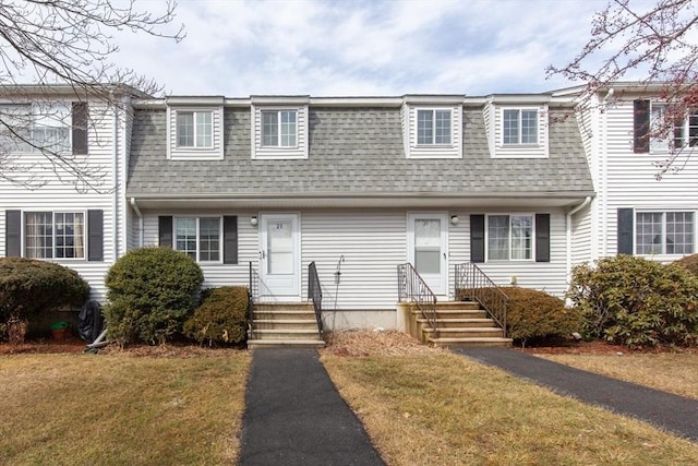 multi unit property with entry steps, a shingled roof, and a front lawn