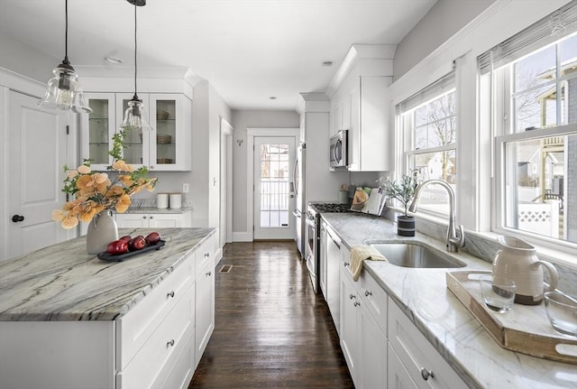 kitchen with light stone counters, stainless steel appliances, and white cabinets