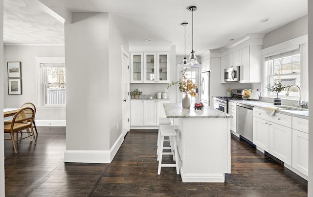 kitchen with white cabinetry, sink, stainless steel appliances, and a center island