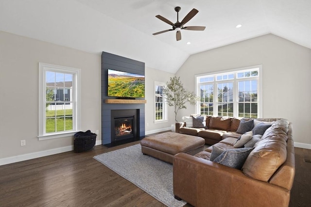 living room featuring baseboards, a fireplace, a ceiling fan, dark wood-style flooring, and vaulted ceiling