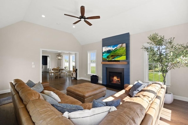 living room with lofted ceiling, wood finished floors, a ceiling fan, baseboards, and a large fireplace