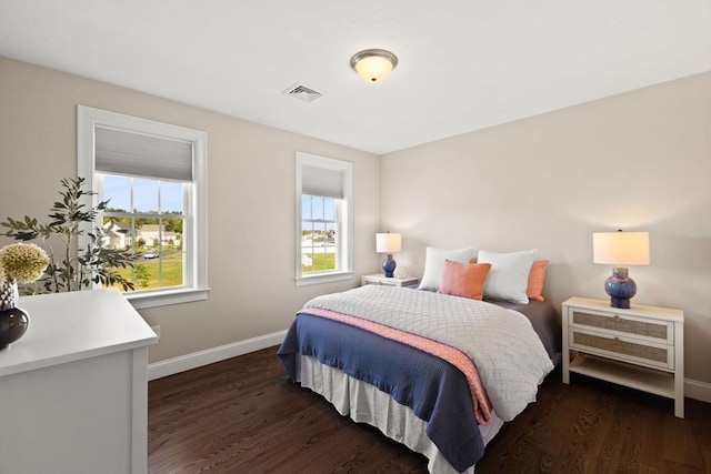 bedroom with baseboards and dark wood-type flooring