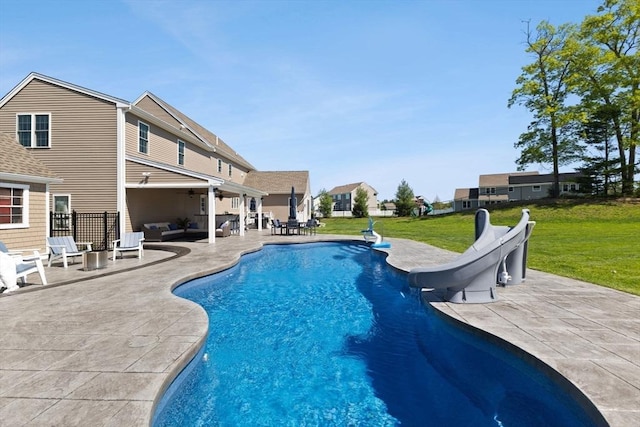 swimming pool with a water slide, an outdoor hangout area, a lawn, a patio, and a ceiling fan