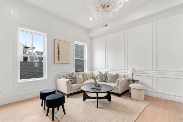 9 Russell Unit 1, Boston, MA 02129 - living area featuring a decorative wall, light wood-style flooring, a chandelier, and crown molding