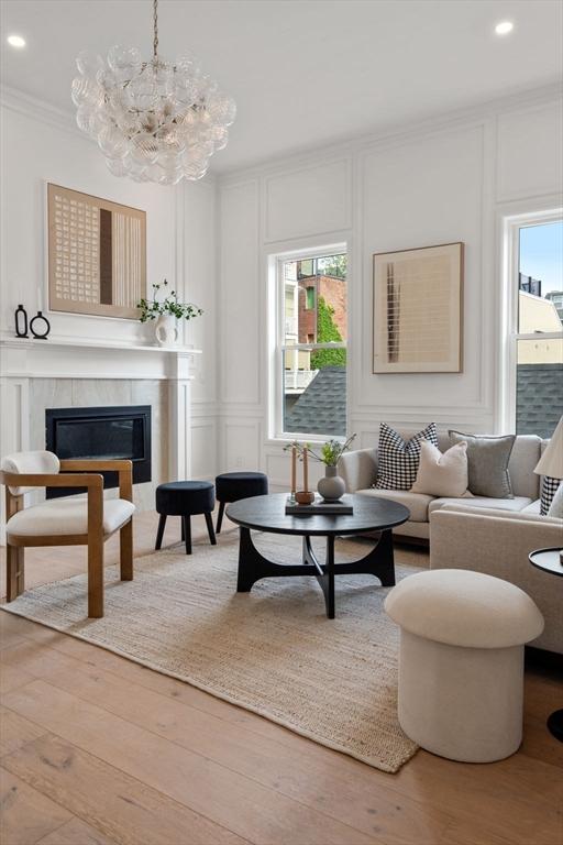 9 Russell Unit 1, Boston, MA 02129 - living area with a decorative wall, a glass covered fireplace, recessed lighting, crown molding, and wood finished floors