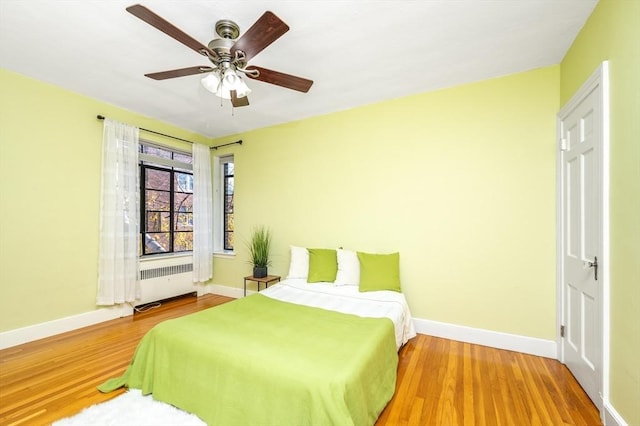 bedroom featuring ceiling fan, light hardwood / wood-style floors, and radiator heating unit